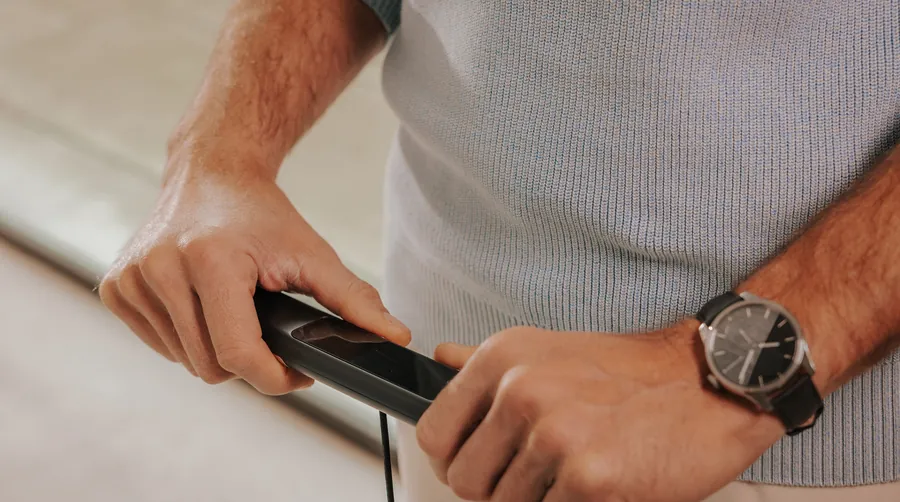 Beide Hände umfassen den ausziehbaren Griff der Withings BodyScan 2